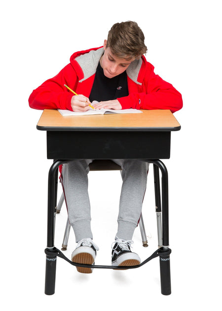 A Young Boy Studying on a Desk with a Black Bouncyband